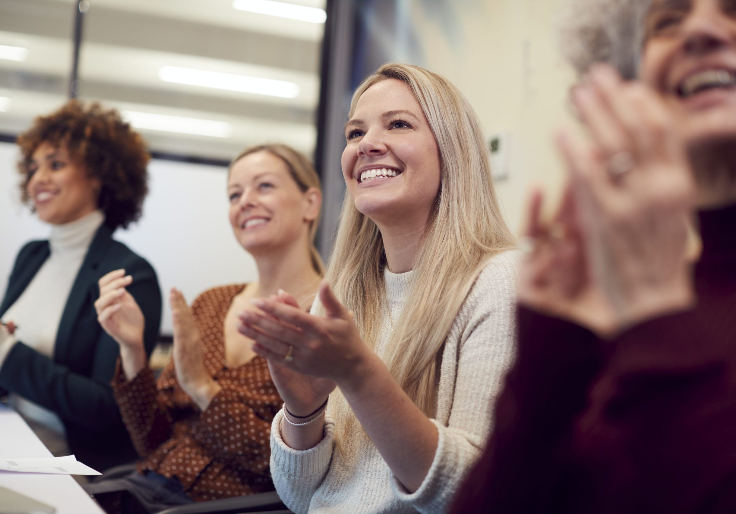 Line Of Businesswomen In Modern Office Applauding Presentation By Colleague